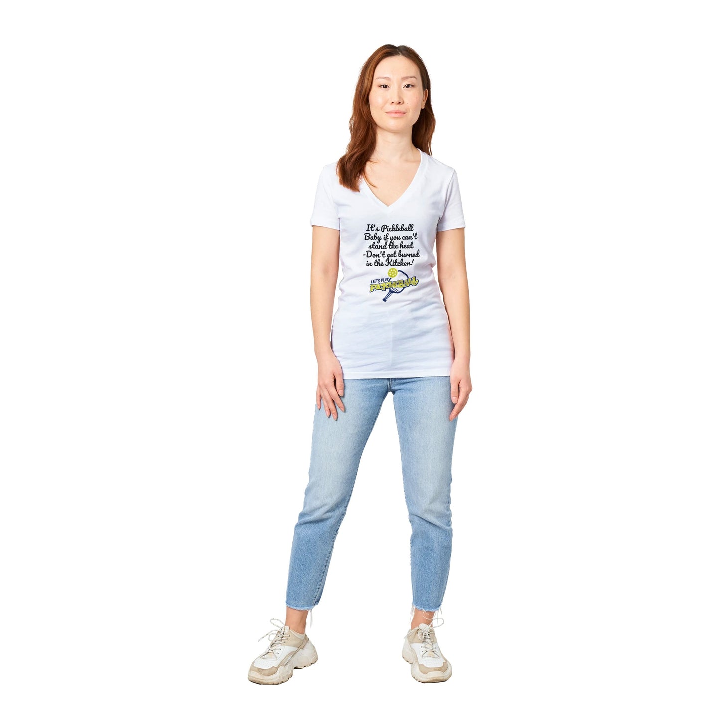 A premium women’s V-neck t-shirt with original logo It's PIckleball Baby if you can't stand the heat - Don't get burned in the Kitchen and Let's Play Pickleball on front from WhatYa Say Apparel worn by Asian Female model standing looking forward.