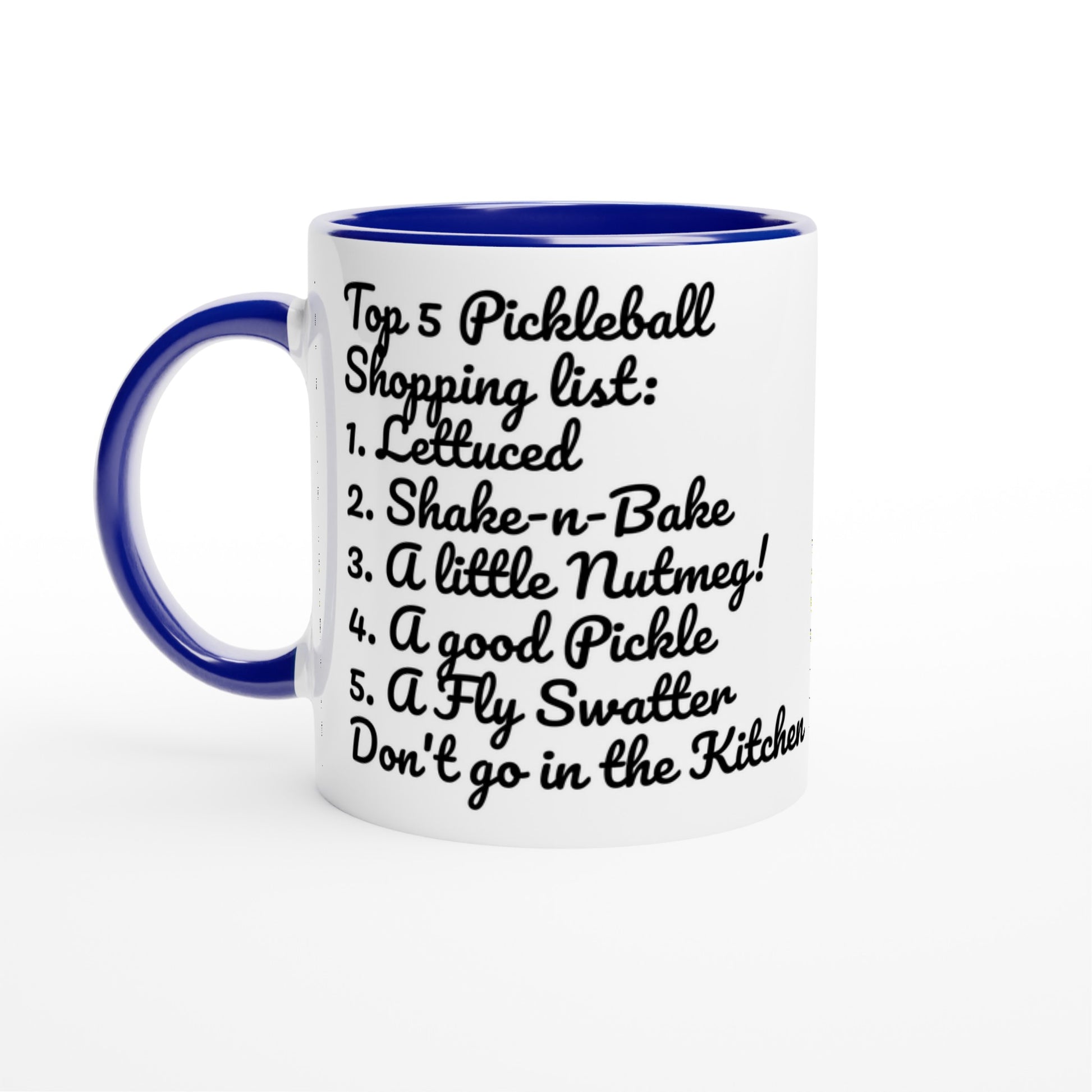 White ceramic 11oz mug with blue handle original motto Top 5 Pickleball Shopping list lettuce, Shake-n-bake, Nutmeg, Pickle, a Fly Swatter Don’t go in the kitchen front side and Let's Play PickleBall logo on back dishwasher and microwave safe ceramic coffee mug from WhatYa Say Apparel front view.