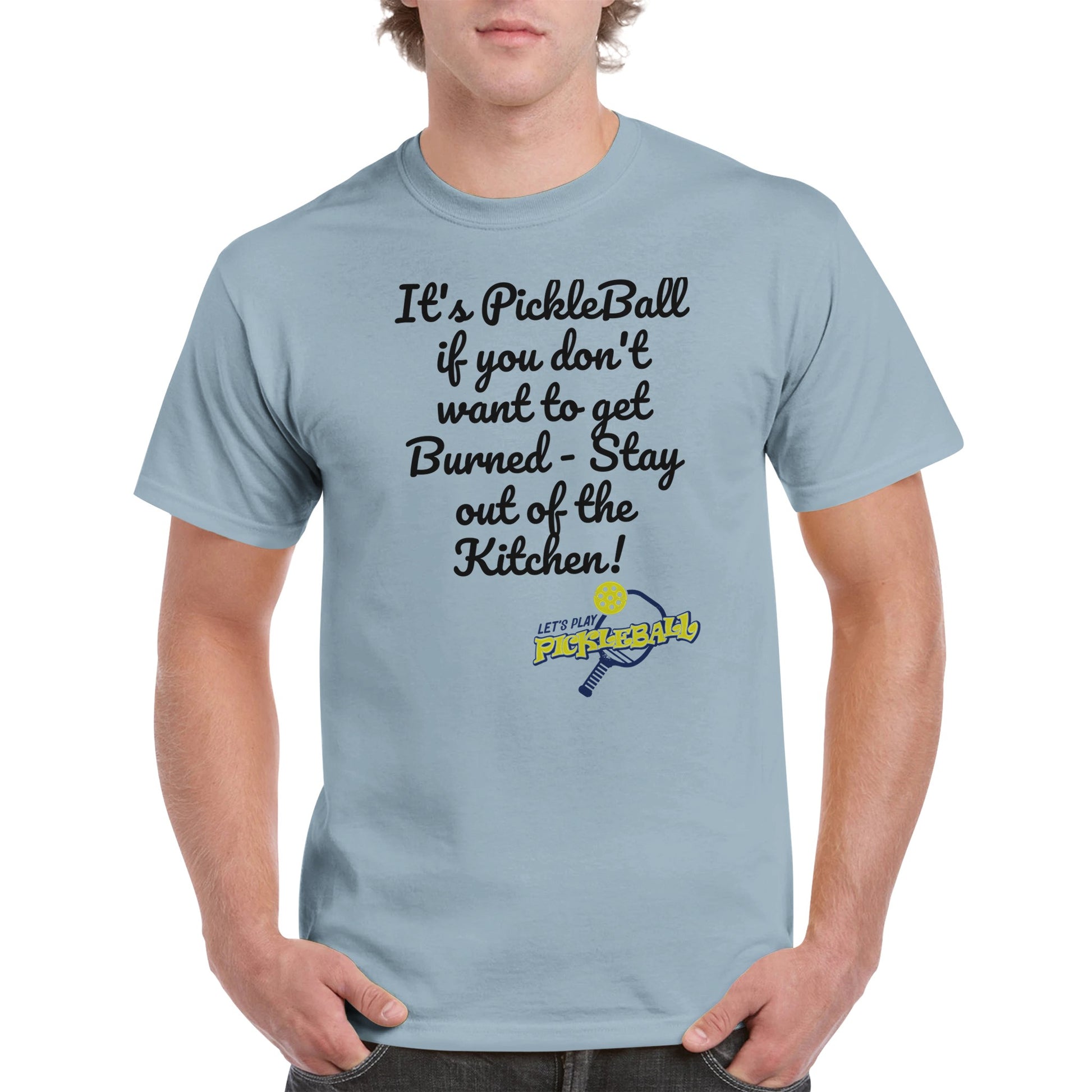 Light blue comfortable Unisex Crewneck heavyweight cotton t-shirt with funny saying It’s PickleBall if you don’t want to get Burned – Stay out of the Kitchen! and Let’s Play Pickleball logo on the front from WhatYa Say Apparel worn by blonde-haired male front view.