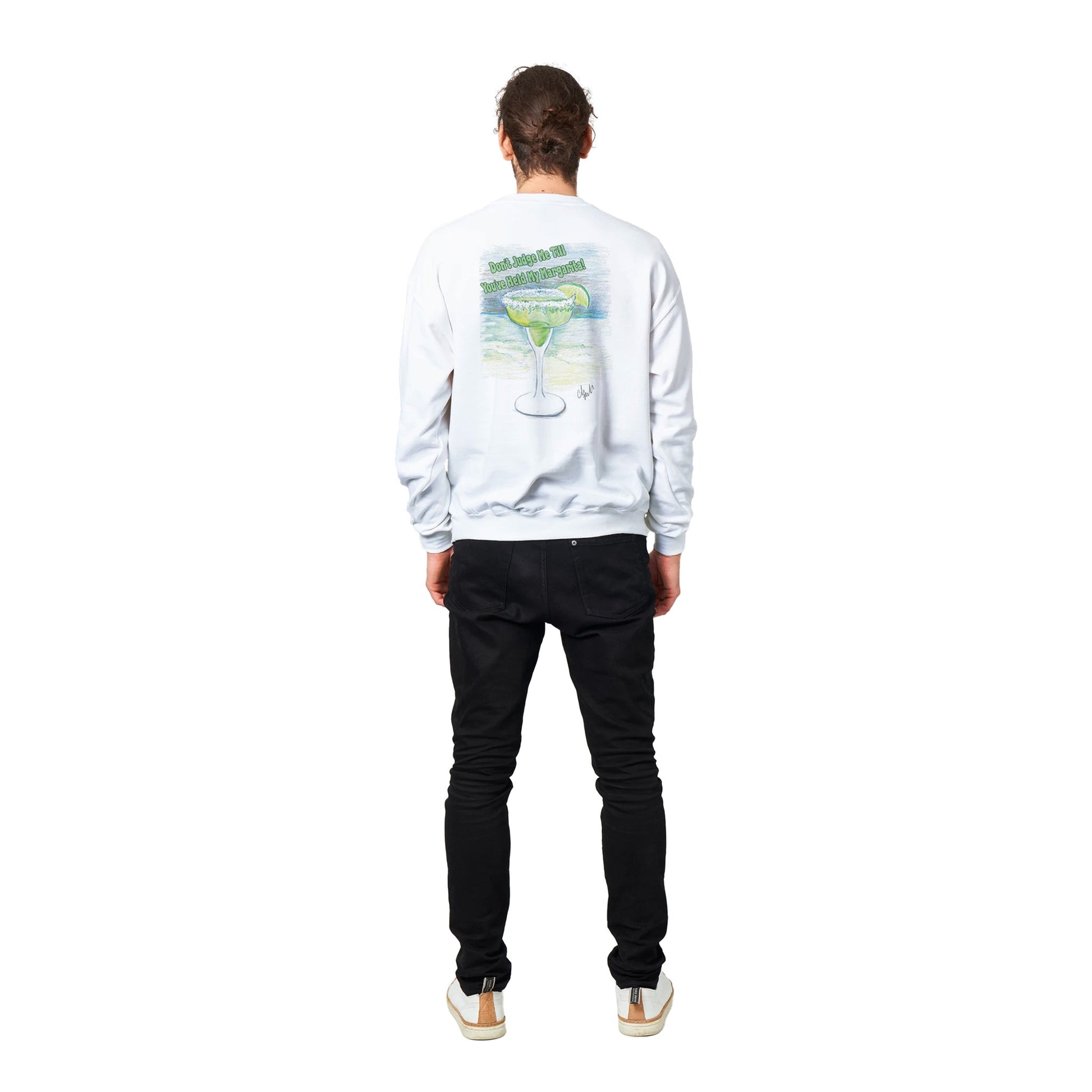 Standing short haired male model wearing a white Classic Unisex Crewneck sweatshirt with original artwork and motto Don’t Judge Me Till You’ve Held my margarita on back and Whatya Say logo on front from WhatYa Say Apparel rear view.