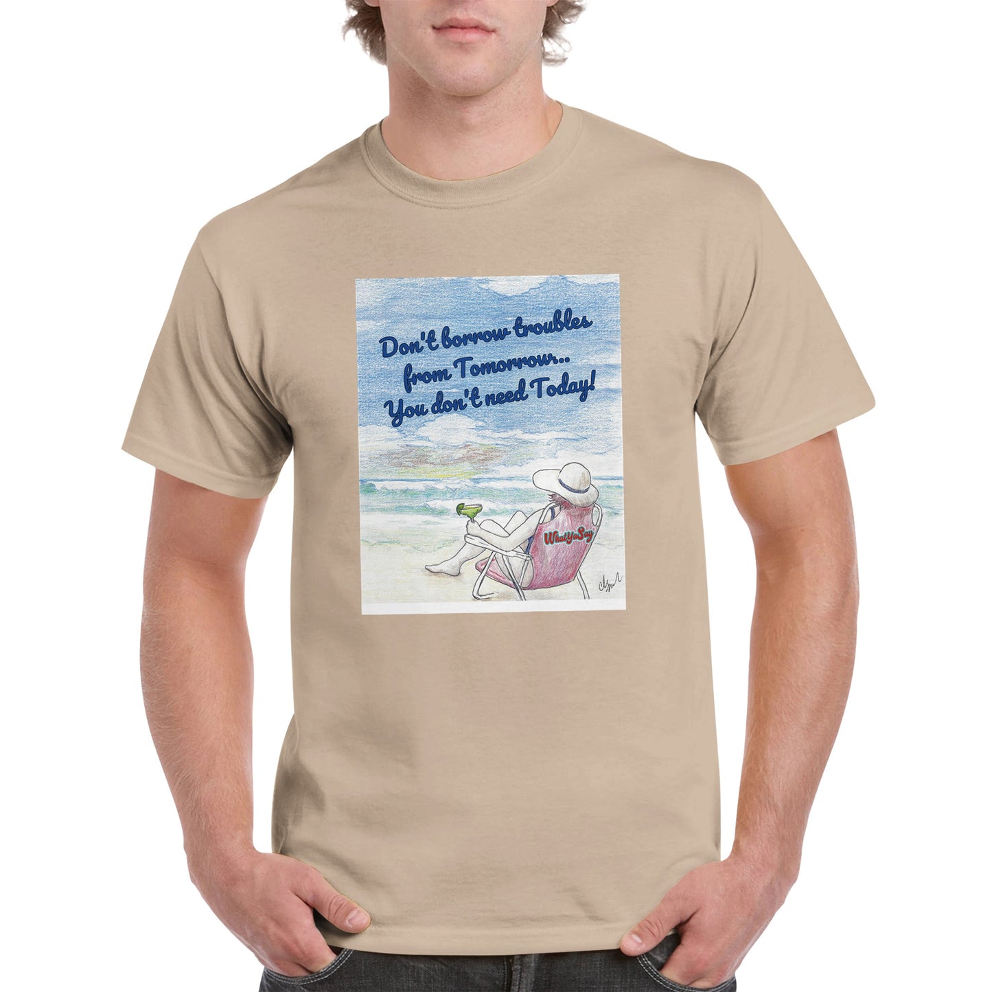 A sand heavyweight Unisex Crewneck t-shirt with original artwork and motto Don’t borrow troubles from Tomorrow… You don’t need Today! on front with WhatYa Say logo on image from WhatYa Say Apparel worn by blonde-haired male front view.