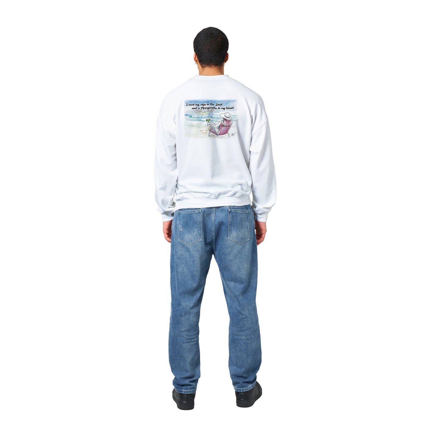 A white Classic Unisex Crewneck sweatshirt with original artwork and motto I need my Ass in the Sand and a Margarita in my Hand on back and Whatya Say logo on front from WhatYa Say Apparel worn by a standing short haired male model rear view.