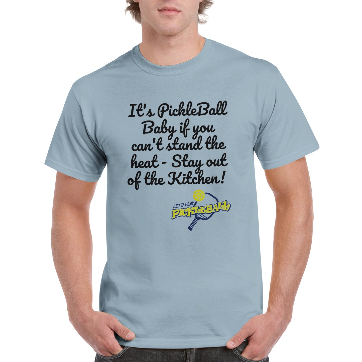 Light blue comfortable Unisex Crewneck heavyweight cotton t-shirt with funny saying It’s PickleBall Baby if can’t stand the heat – Stay out of the Kitchen!  and Let’s Play Pickleball logo on the front from WhatYa Say Apparel worn by blonde-haired male front view.
