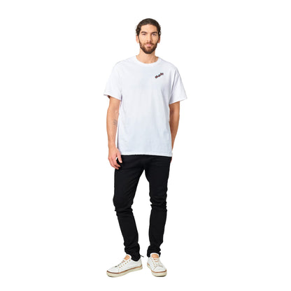 A white heavyweight Unisex Crewneck t-shirt with original artwork and I need my Ass in the Sand and a Margarita in my hand on back with WhatYa Say logo on front from WhatYa Say apparel worn by short brown-haired male model standing.