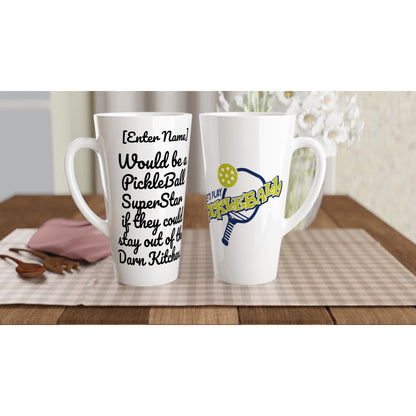 Two Personalized Seventeener white ceramic 17oz mug with original personalized motto [Your Name] Would be a PickleBall SuperStar if they could stay out of the Darn Kitchen! on front and Let’s Play Pickleball logo on back coffee mug dishwasher and microwave safe from WhatYa Say Apparel sitting on coffee table with green and white placemat.