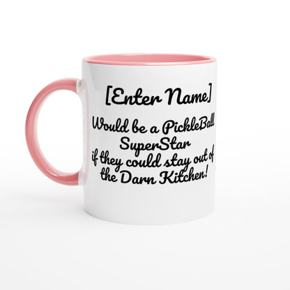 White ceramic 11oz mug with pink handle Personalized with motto Your Name Would be a PickleBall Superstar if they could stay out of the Darn Kitchen front side Let's Play PickleBall logo on back dishwasher and microwave safe ceramic coffee mug from WhatYa Say Apparel front view.