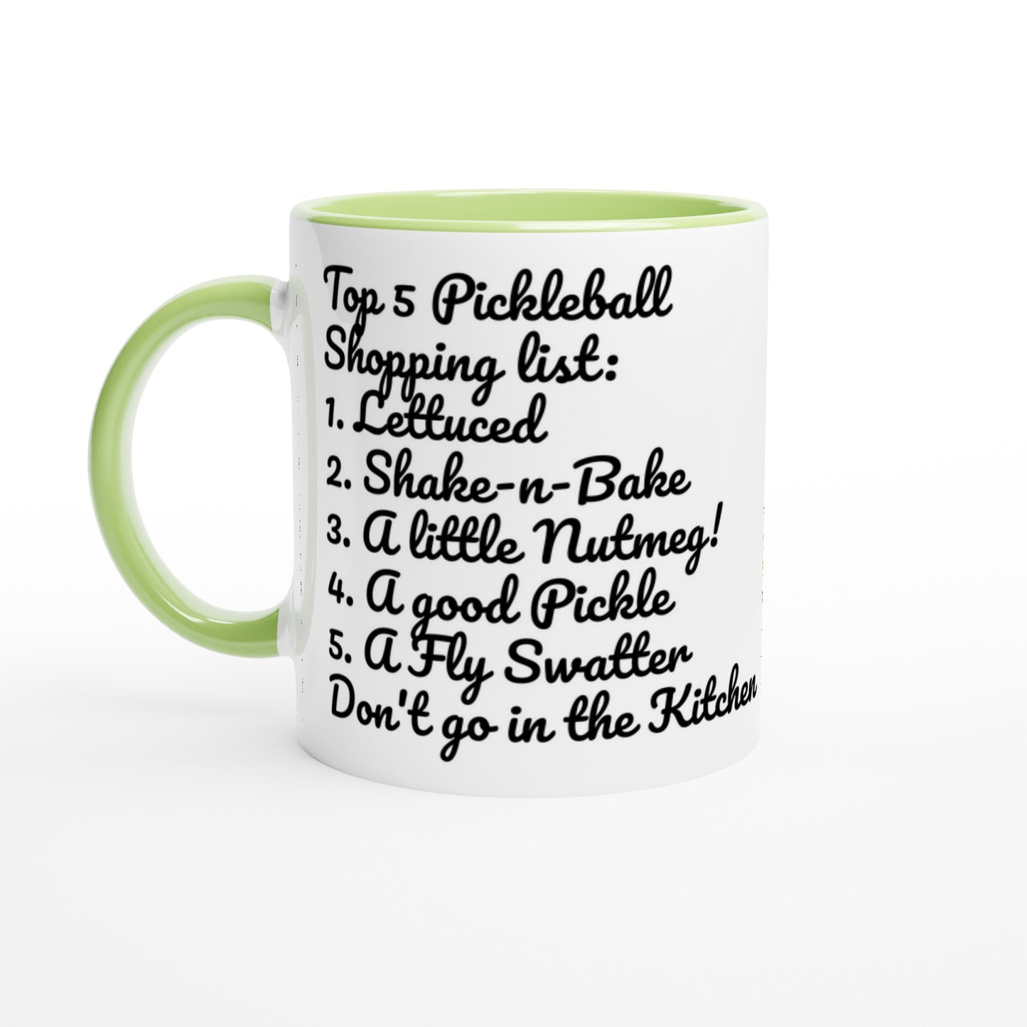 White ceramic 11oz mug with green handle original motto Top 5 Pickleball Shopping list lettuce, Shake-n-bake, Nutmeg, Pickle, a Fly Swatter Don’t go in the kitchen front side and Let's Play PickleBall logo on back dishwasher and microwave safe ceramic coffee mug from WhatYa Say Apparel front view.