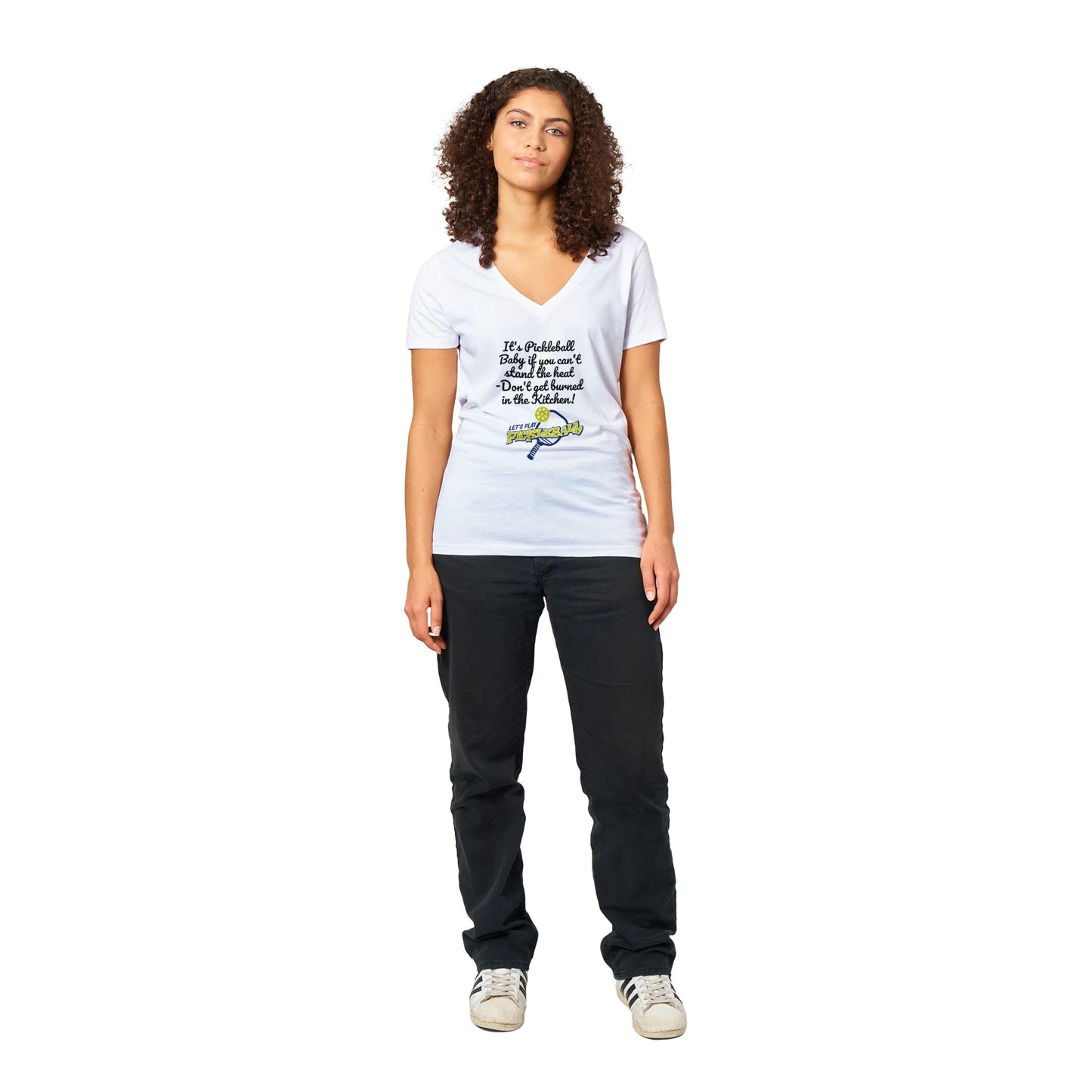 A premium women’s V-neck t-shirt from combed and ring-spun cotton original logo It's PIckleball Baby if you can't stand the heat - Don't get burned in the Kitchen and Let's Play PickleBall on front worn by a dark-haired female model standing.