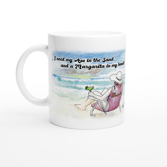 White ceramic 11oz mug with white handle and motto I need my Ass in the Sand and a Margarita in my hand front side and WhatYa Say logo on back dishwasher and microwave safe ceramic coffee mug from WhatYa Say Apparel front view.