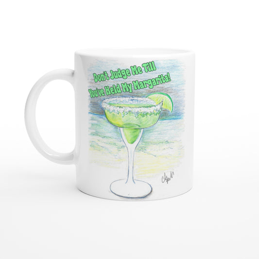 White ceramic 11oz mug with motto Don't Judge Me till You've Held my Margarita dishwasher and microwave safe ceramic coffee mug from WhatYa Say Apparel.